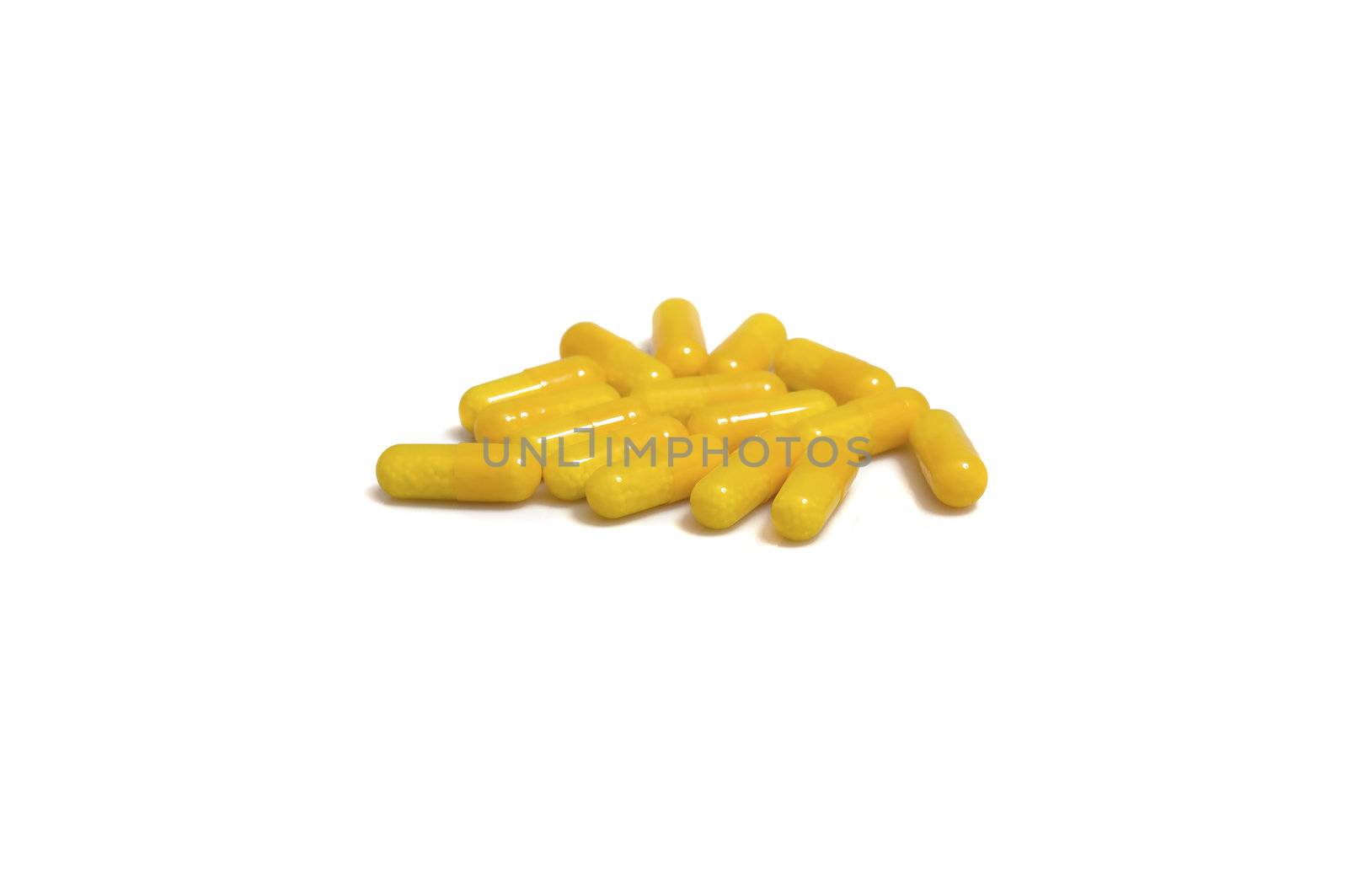 close up of a stack of yellow capsules, isolated on white