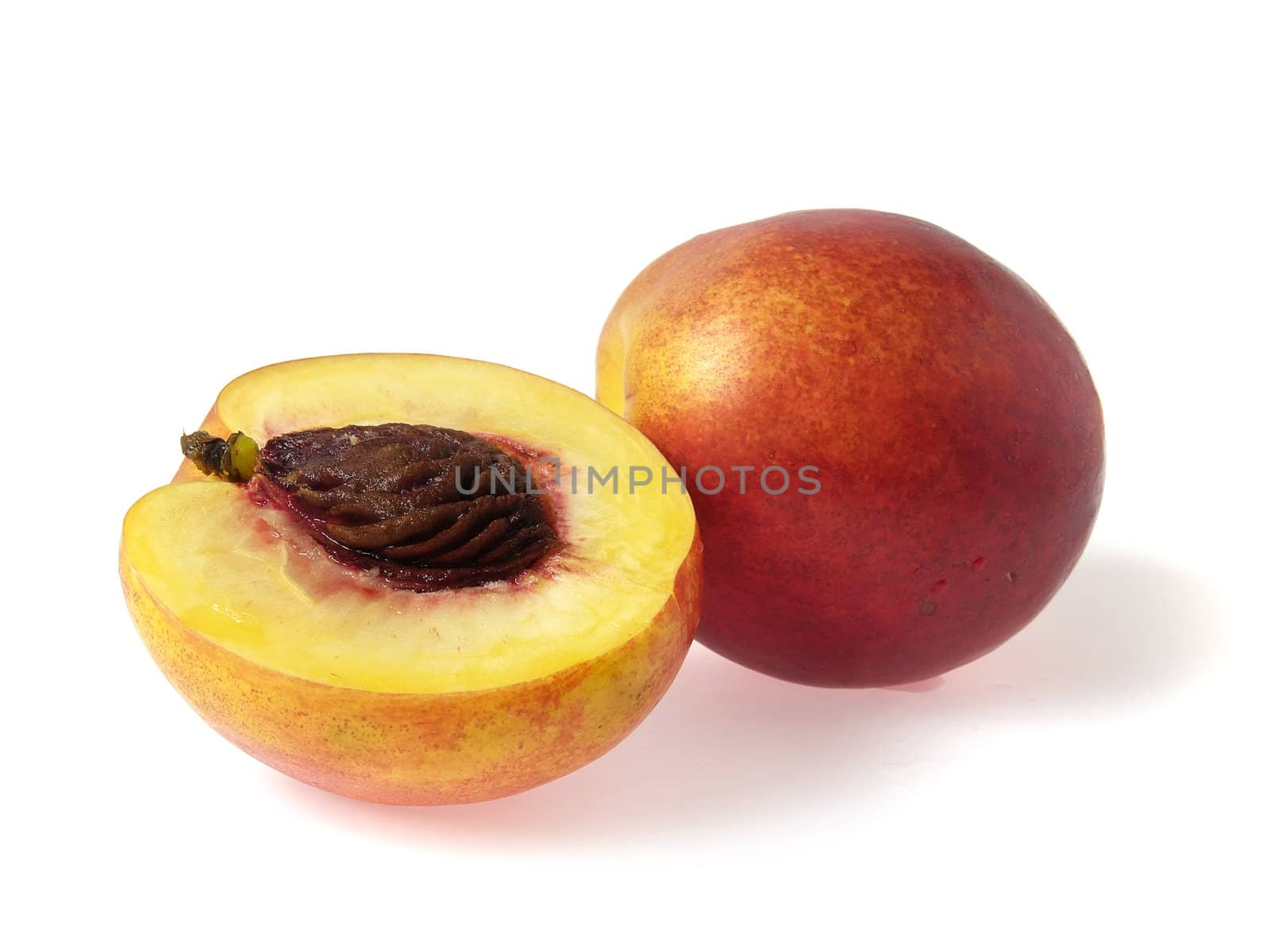Tasty juicy nectarine and half on a white background with water droplets