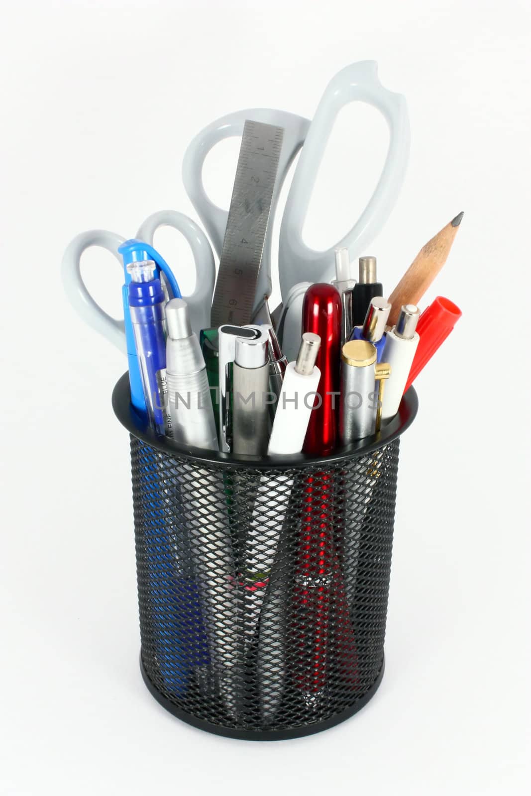 Black metal pencil cup filled with colorful used pencils, pens and scissors, isolated