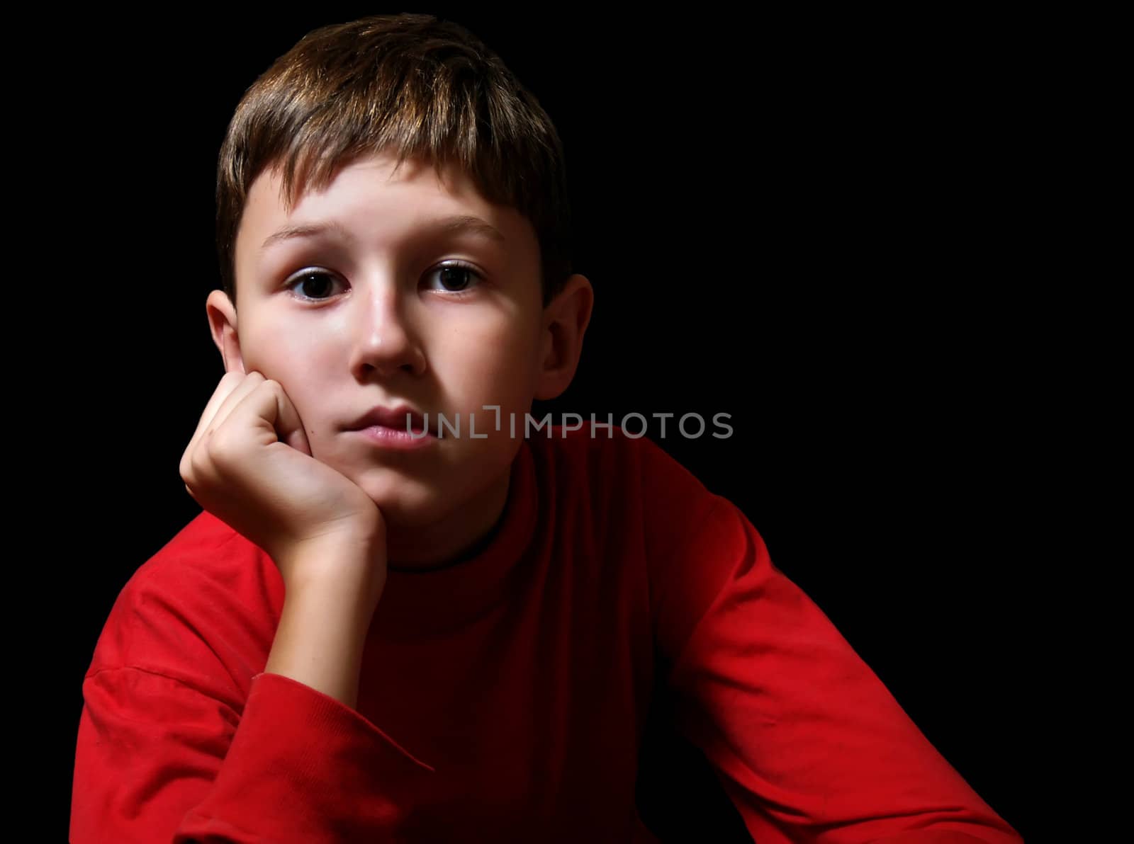 The thoughtful boy in a dark room