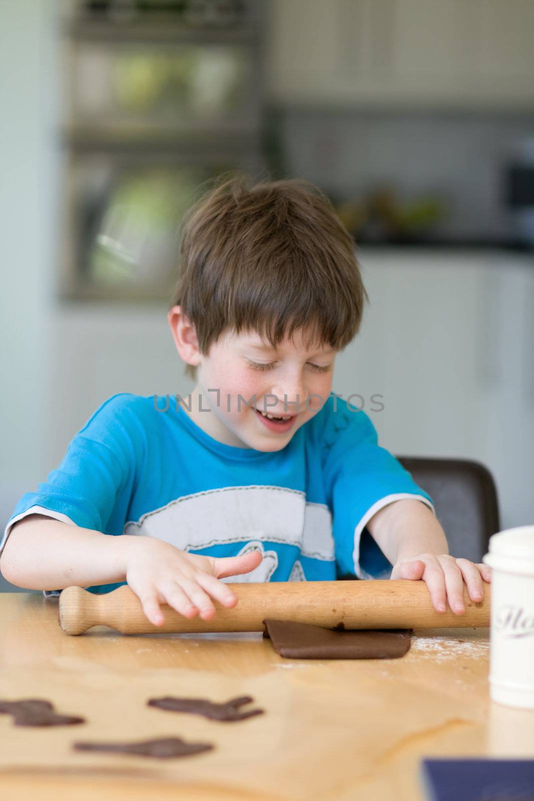 Boy rolling out dough with a rolling pin