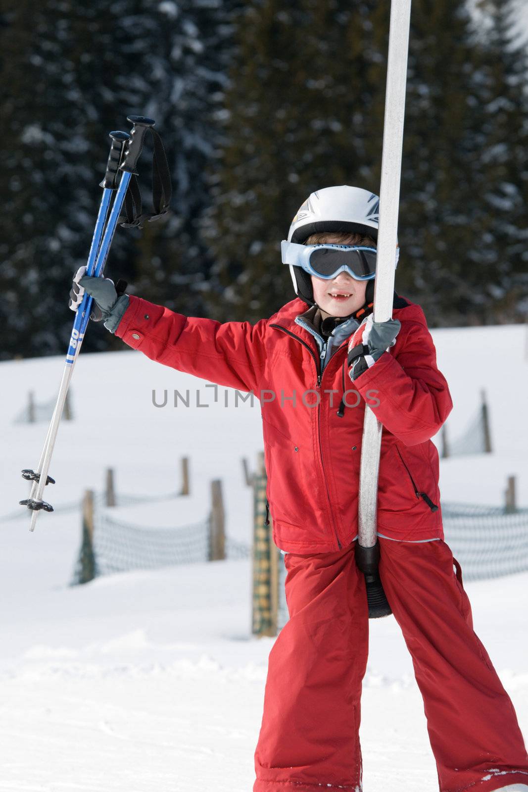Smiling boy on a ski lift carrying ski poles