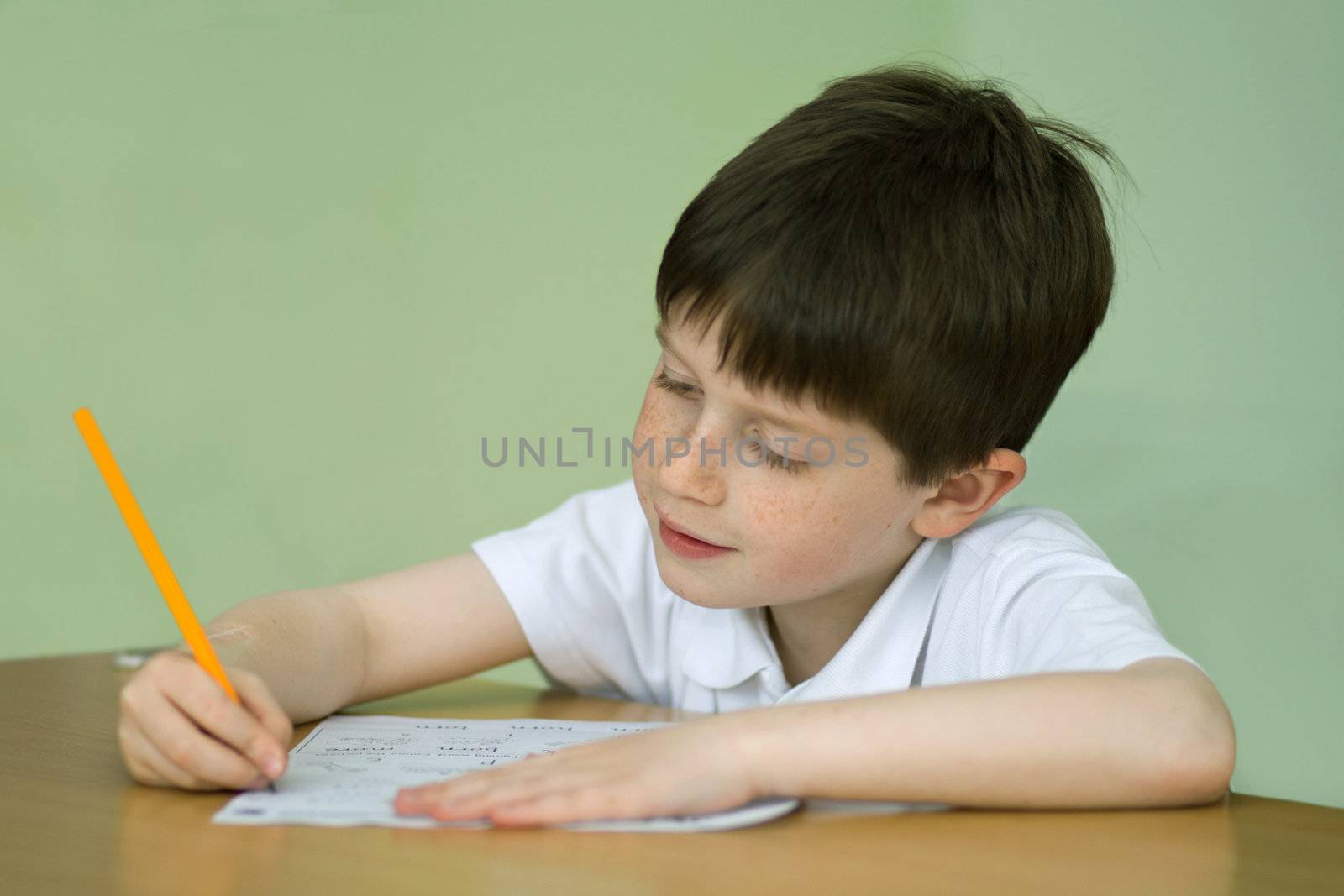 Young boy at a table doing school work