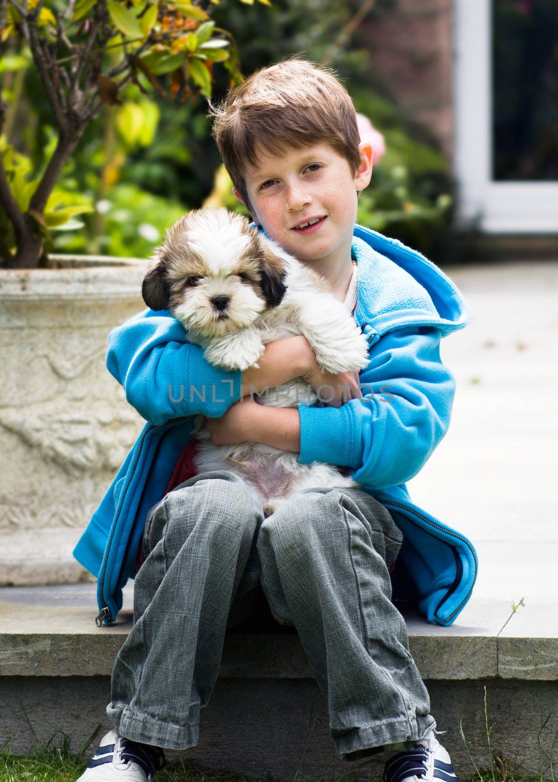 Happy young boy with his pet puppy