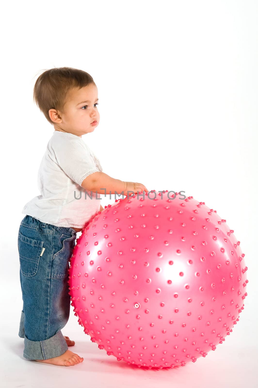 Thoughtful dark hired boy with pink fitness ball on white background