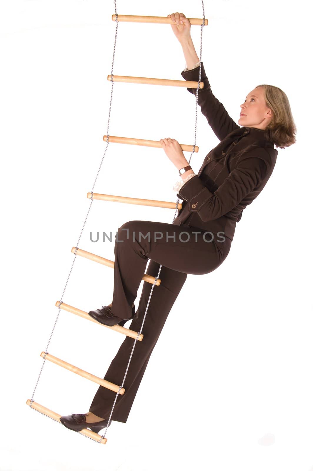 Young woman in brown suit climbering  the rope-ladder isolated on white