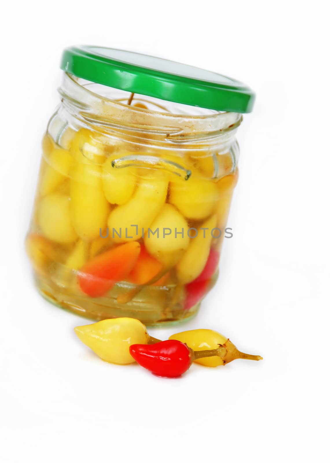 small yellow pickled hot peppers in opened jar on table