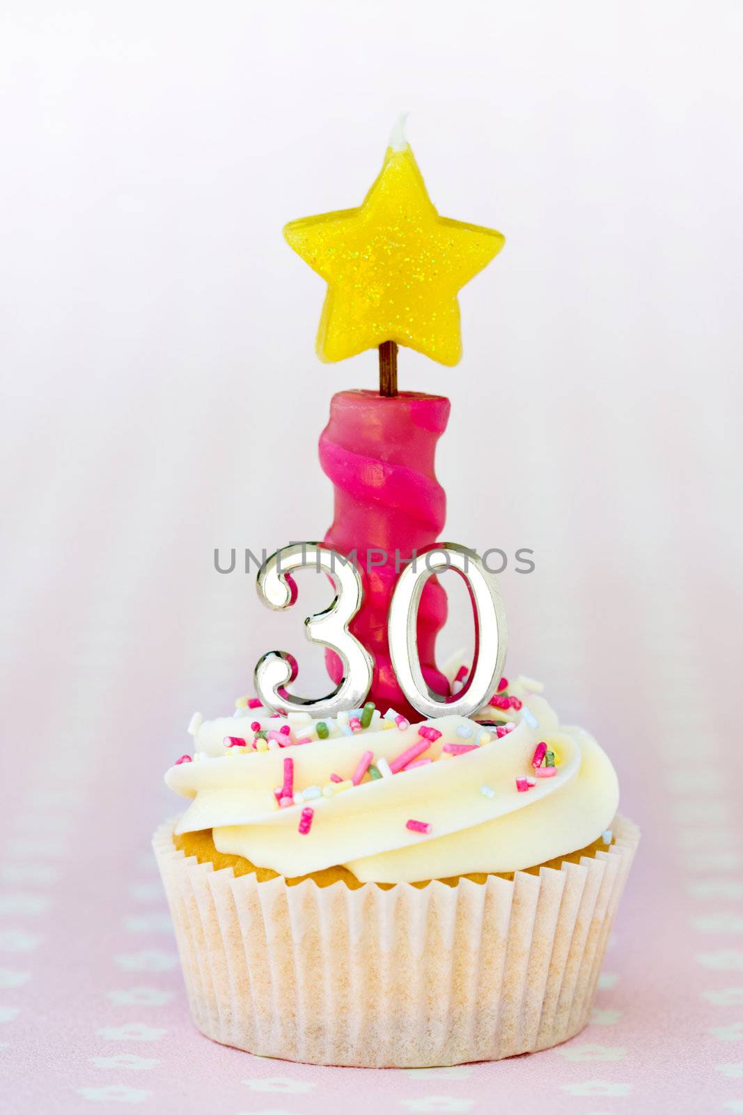 Mini thirtieth birthday cake decorated with a single candle