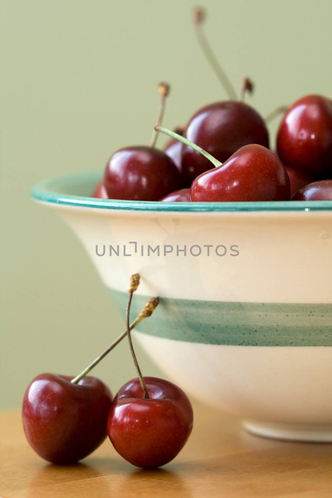 Black cherries in a green striped bowl