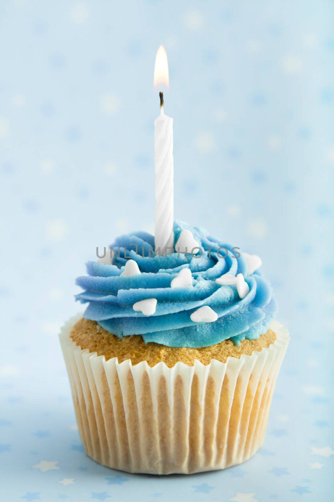 Cupcake decorated with blue frosting and a single candle