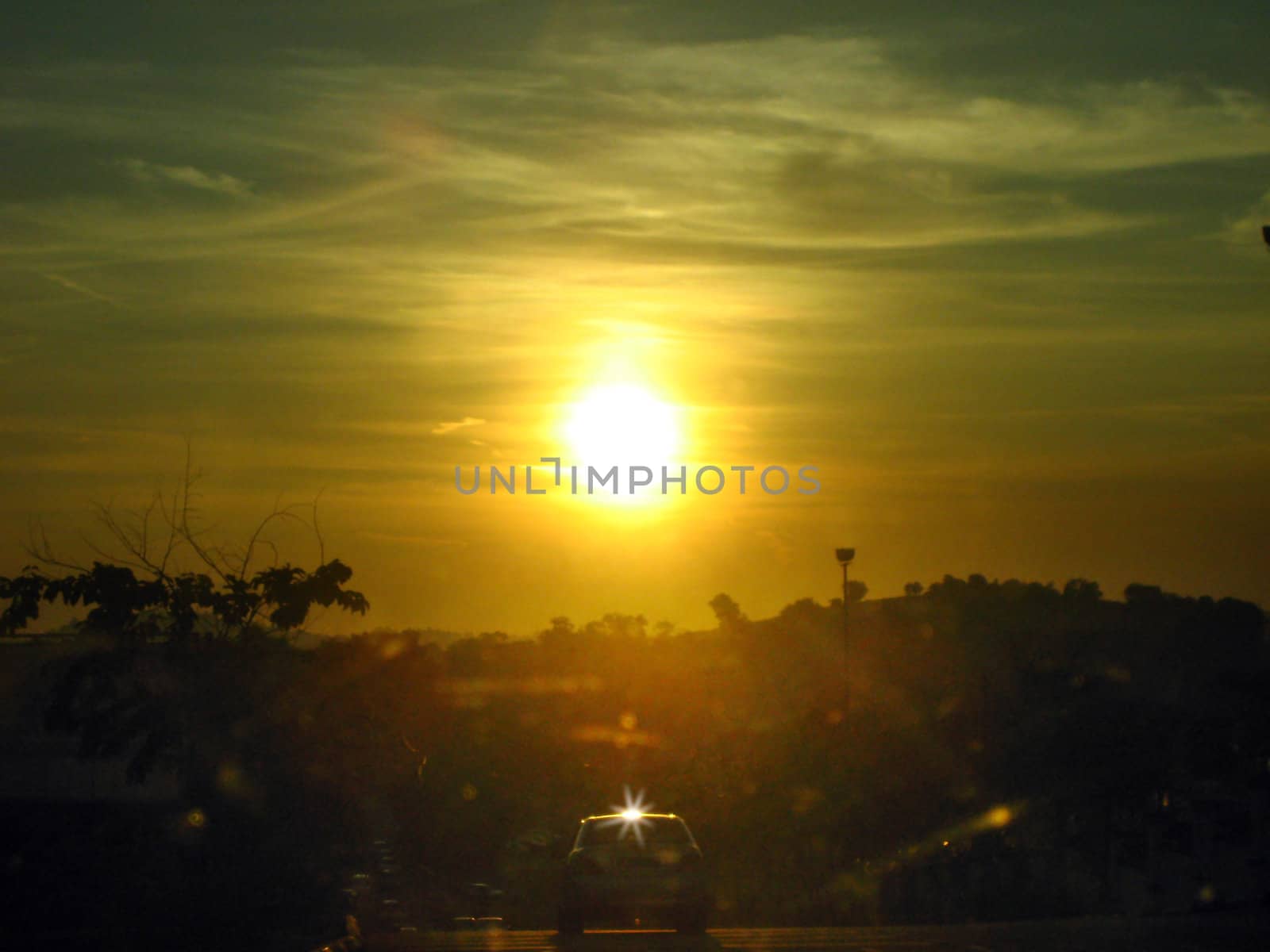 a car on the way back home under a golden light sunset