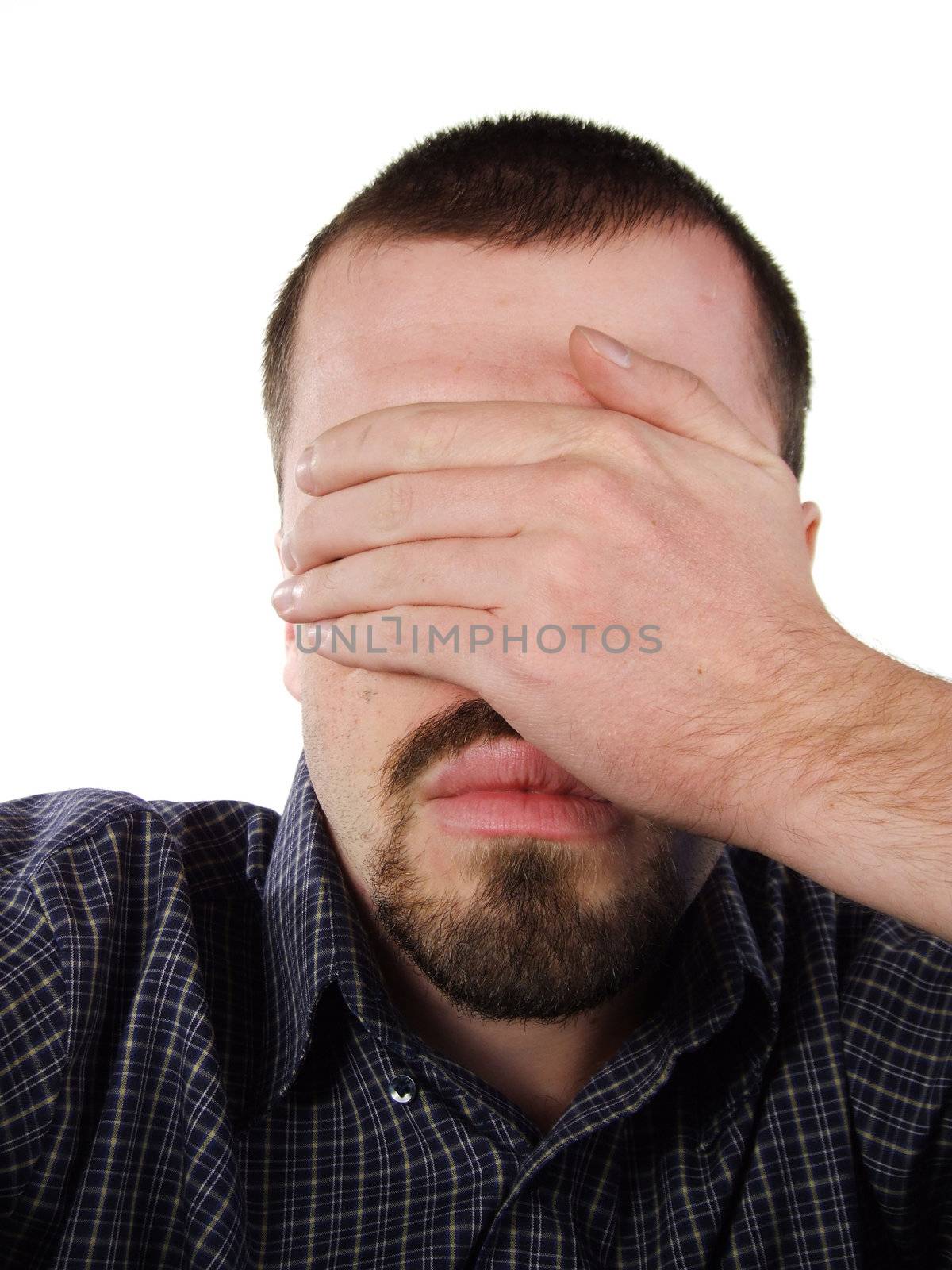 Young Caucasian male covering his eyes with his hand.