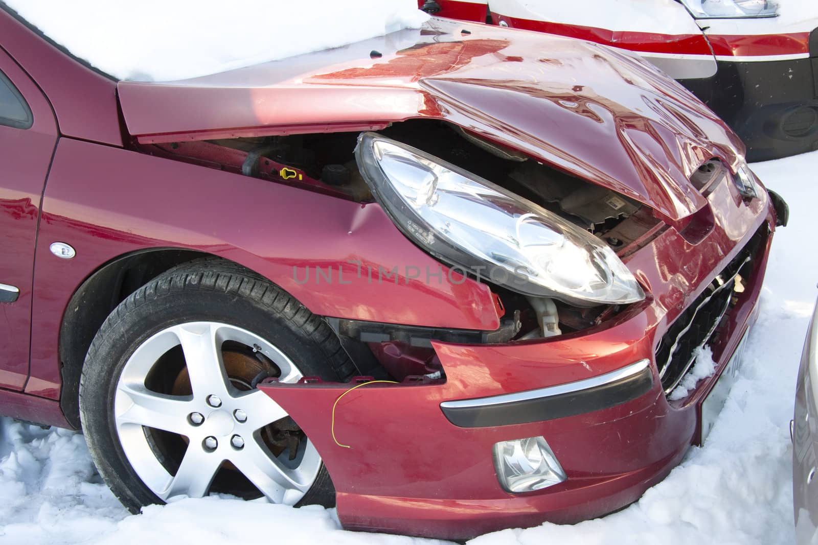 Red car in winter crushed. Damage front of vehicle.