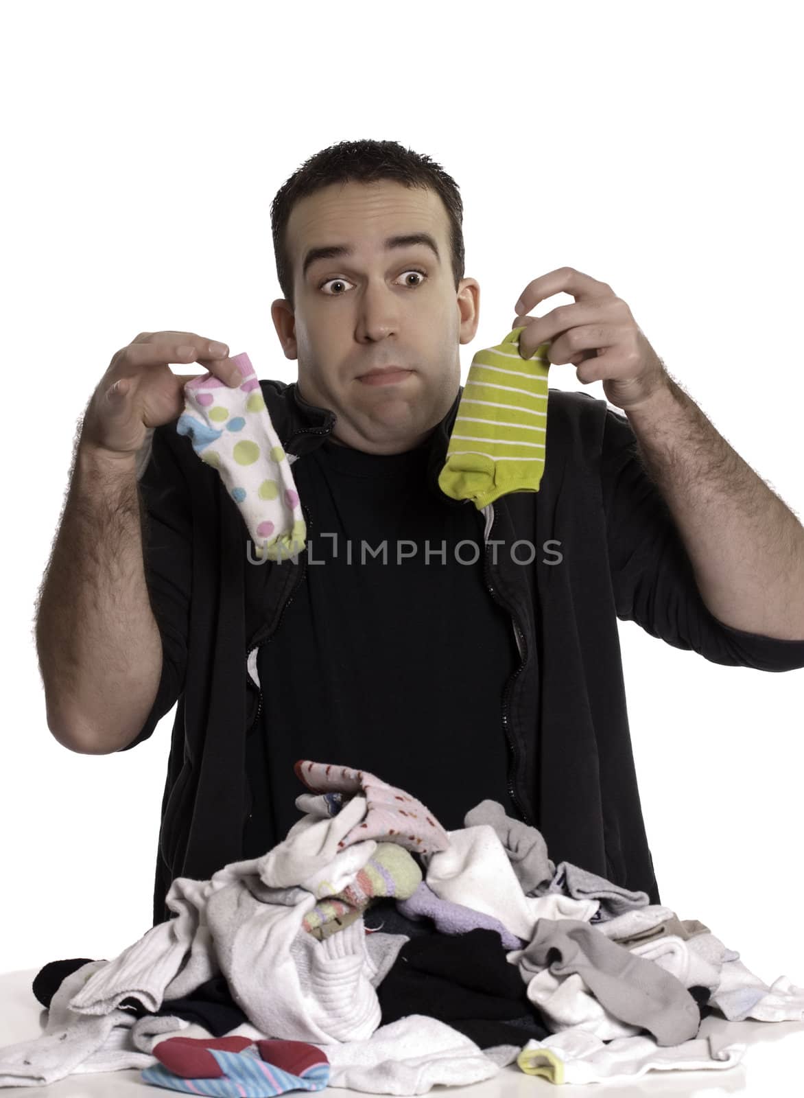 A young man doesn't know how to match socks, isolated against a white background