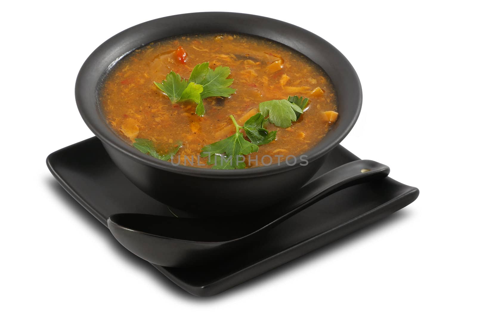 Tasty vegetable soup served in stylish, black bowl, on white, isolated