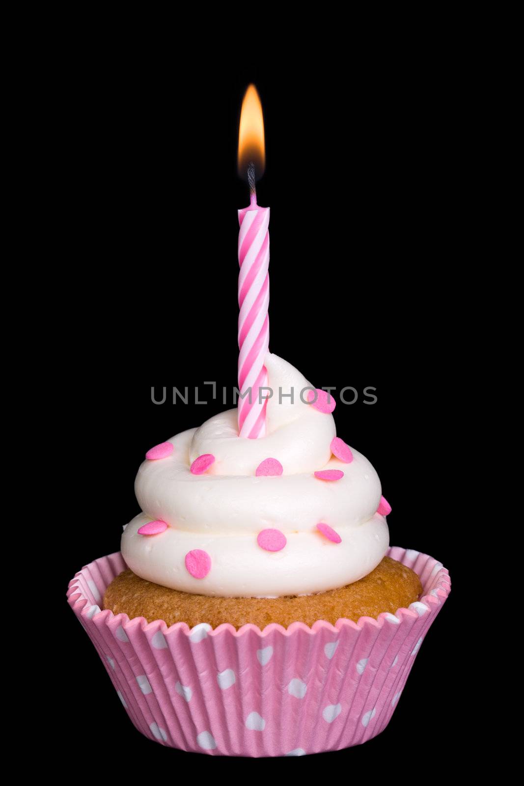 Spotty pink cupcake with a single candle against black