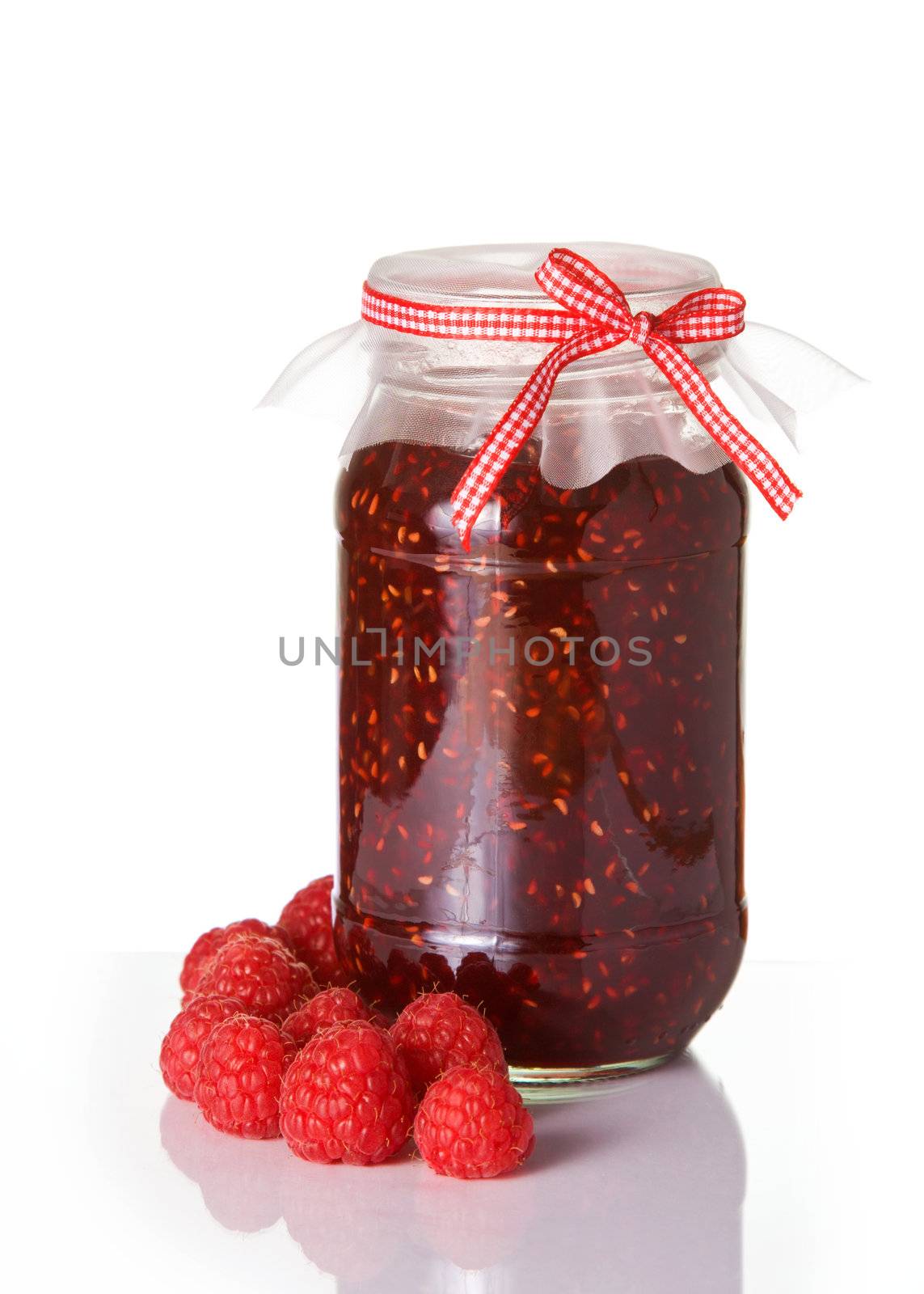 Jar of homemade raspberry jam tied with a gingham ribbon