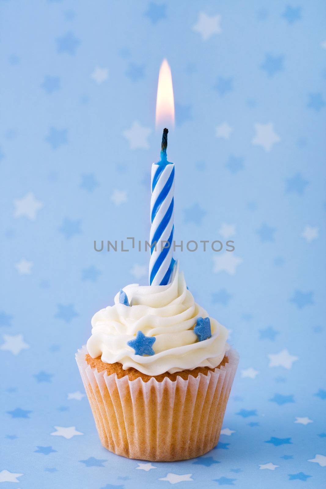 Mini birthday cupcake against a blue starry background