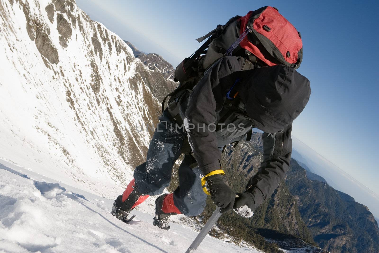 Mountain climber use ice axe to walk on snow ice slop in winter.