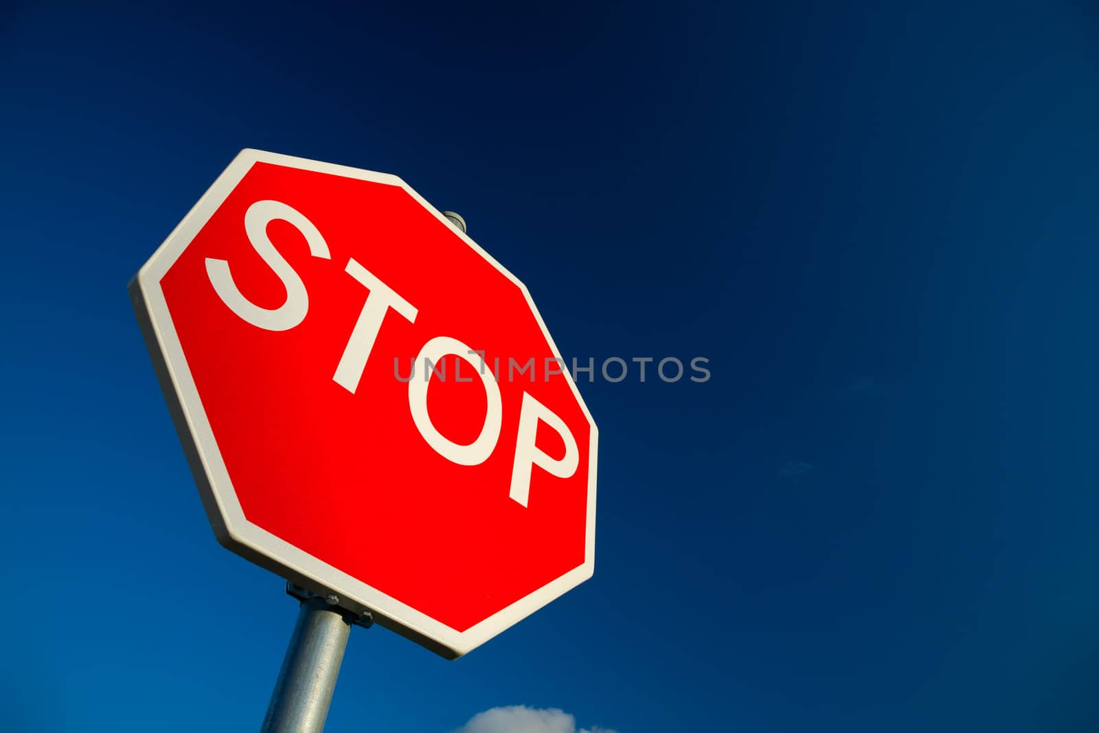 Stop sign against deep blue sky.