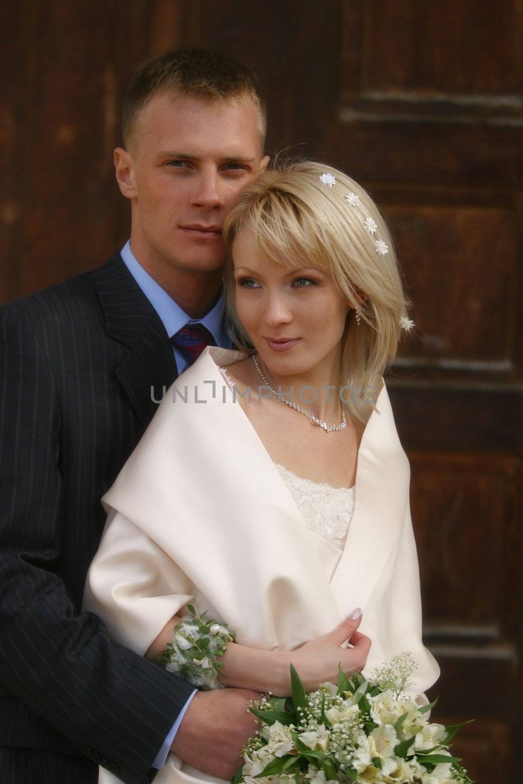 The groom and the bride on a background of a brown door