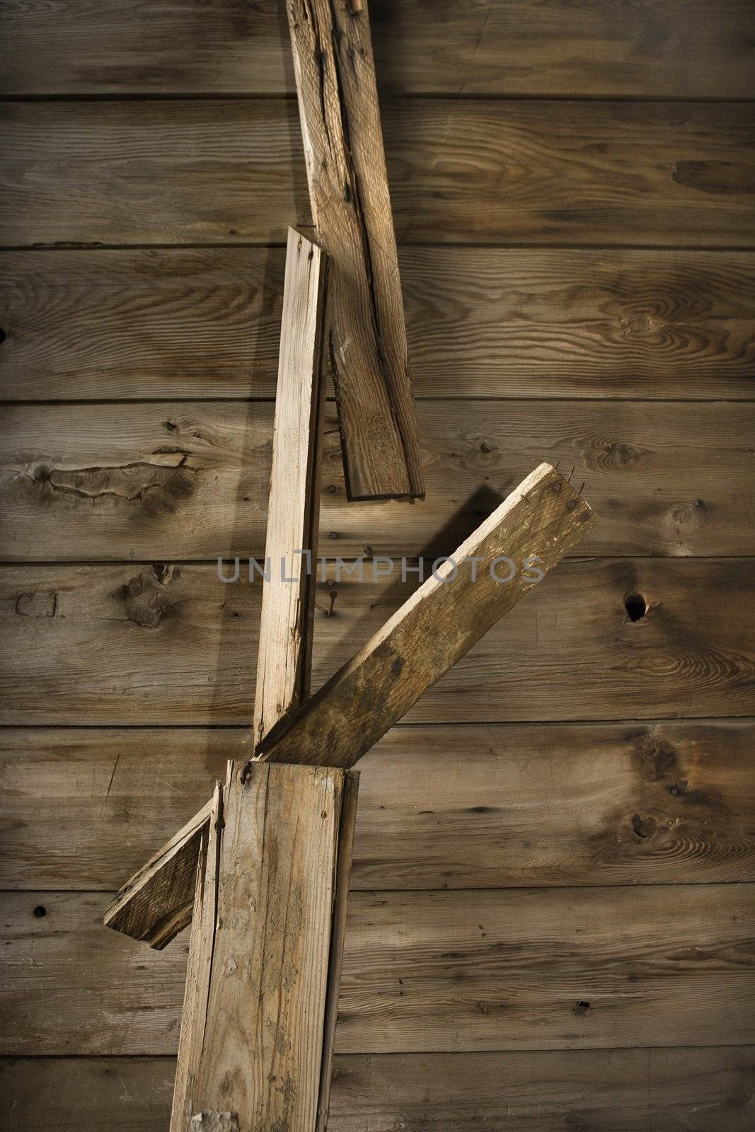 Close up detail of side of rustic wooden building with wood pieces hanging down.