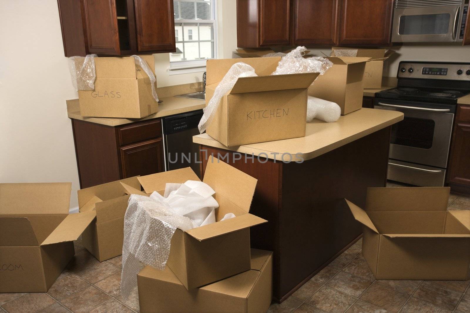 Moving boxes in kitchen. by iofoto