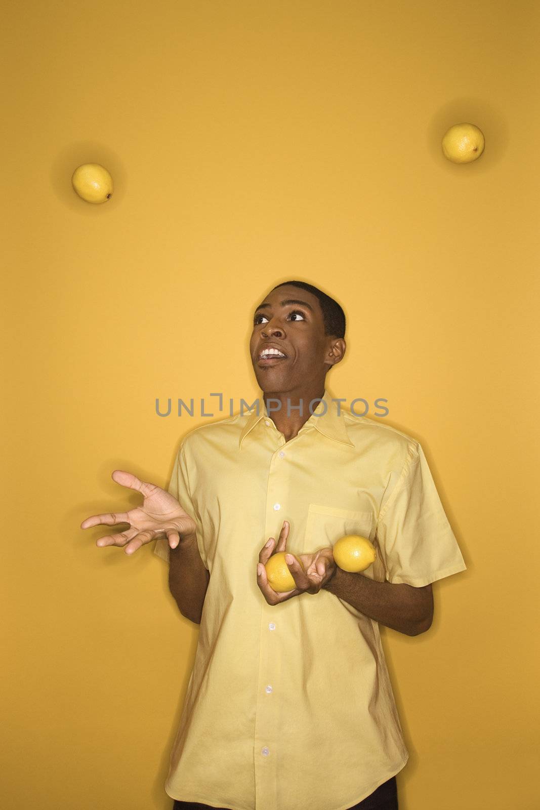 Man juggling lemons. by iofoto