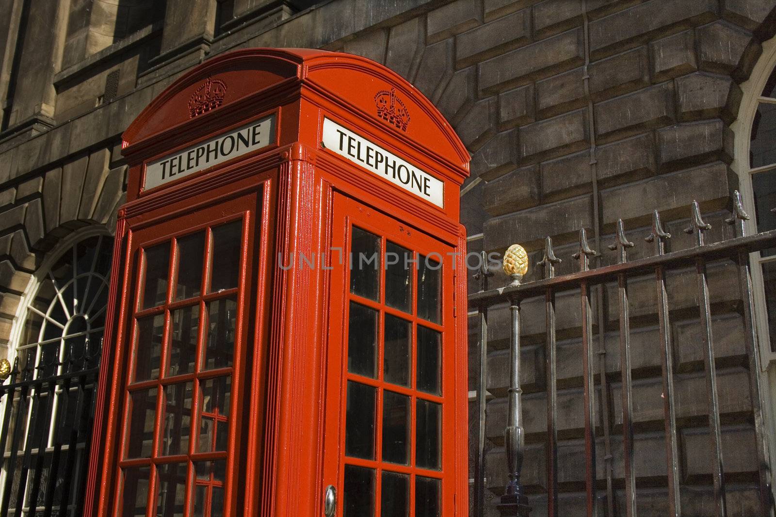 Classic bright red British telephone box set against ornate building