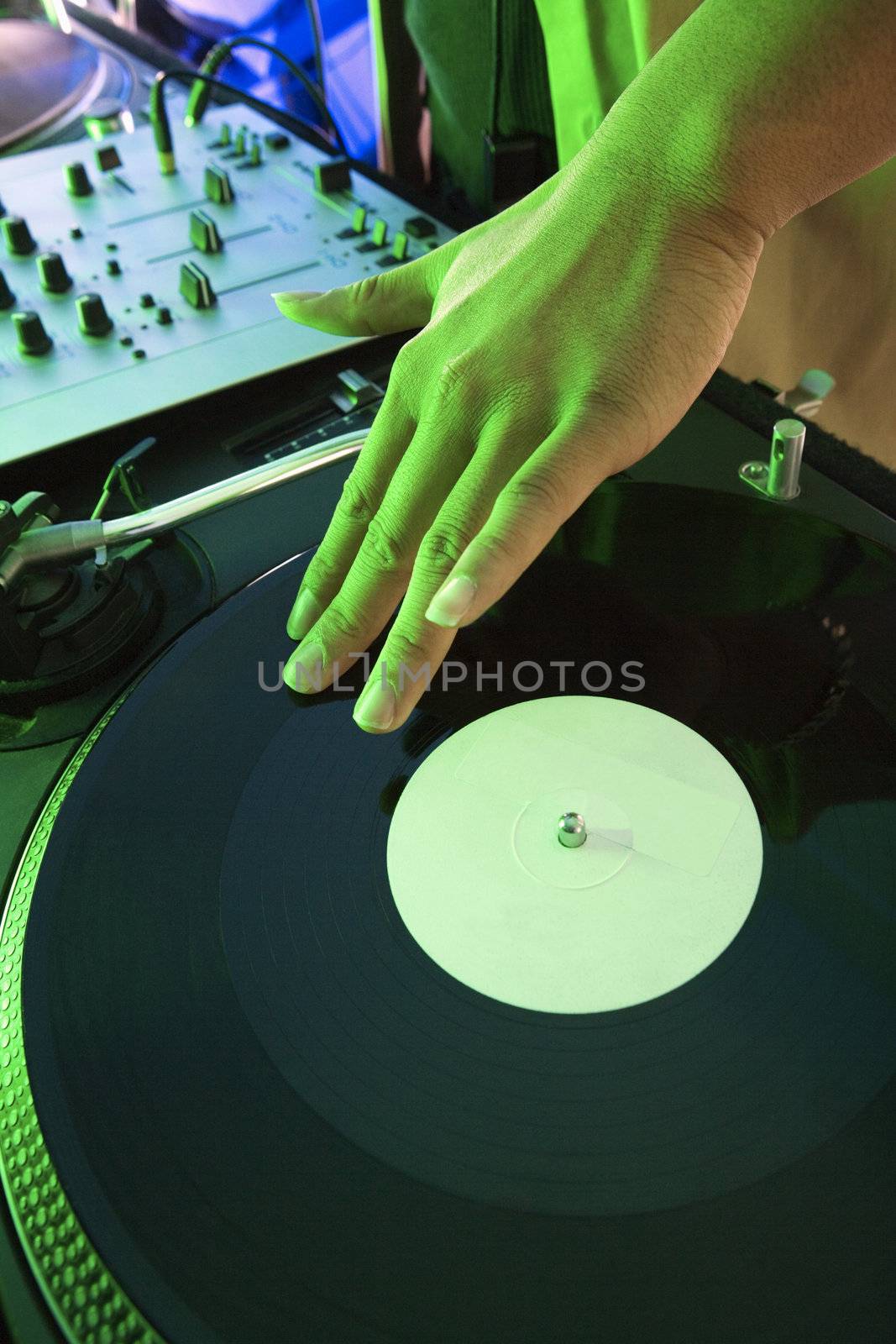 Close-up of Asian young adult male DJ's hand spinning vinyl record.