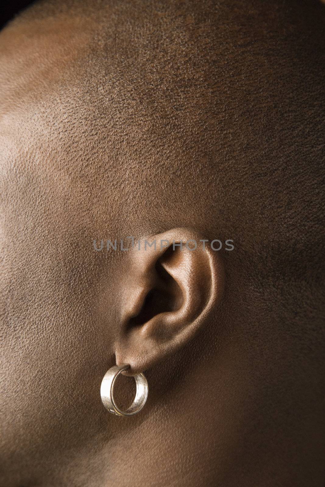 Man's ear with earring. by iofoto