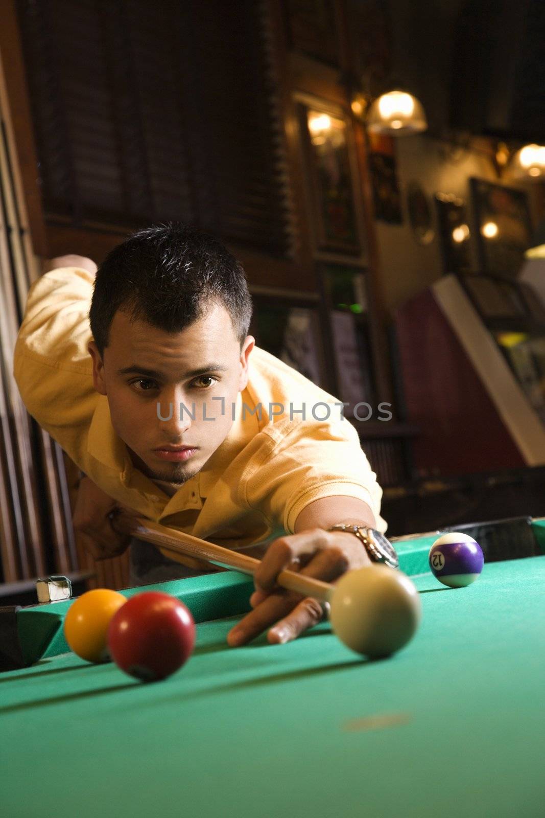 Man playing billiards. by iofoto