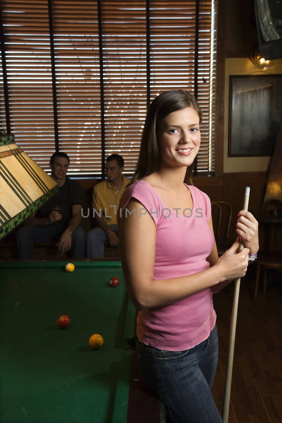Woman holding poolstick. by iofoto