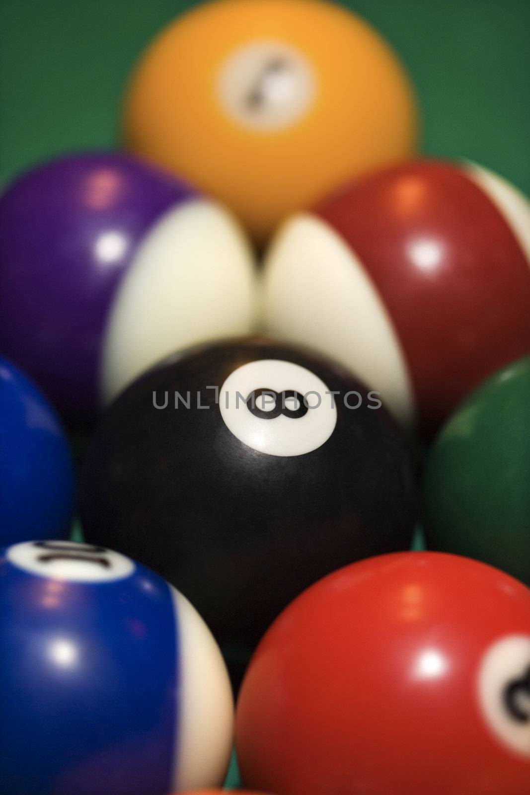 Close-up of rack of pool balls on green billiards table.