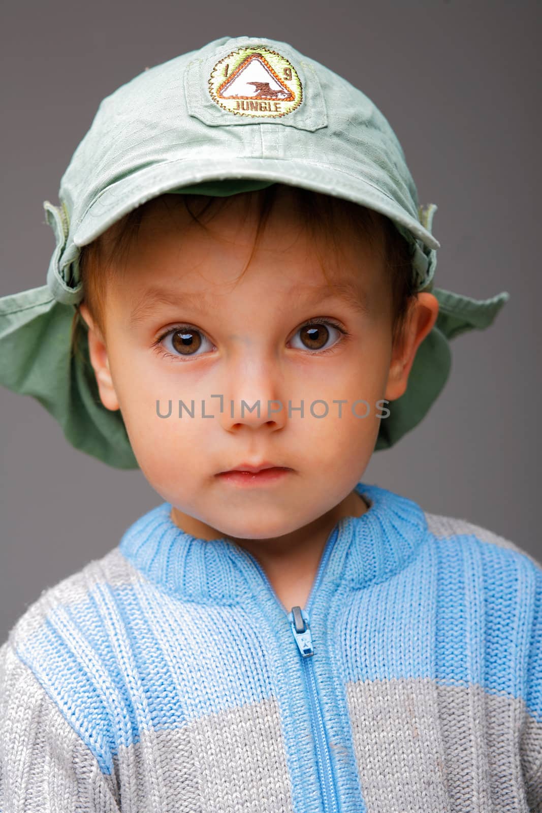 Closeup portrait of a little boy in a cap, serious attentive look