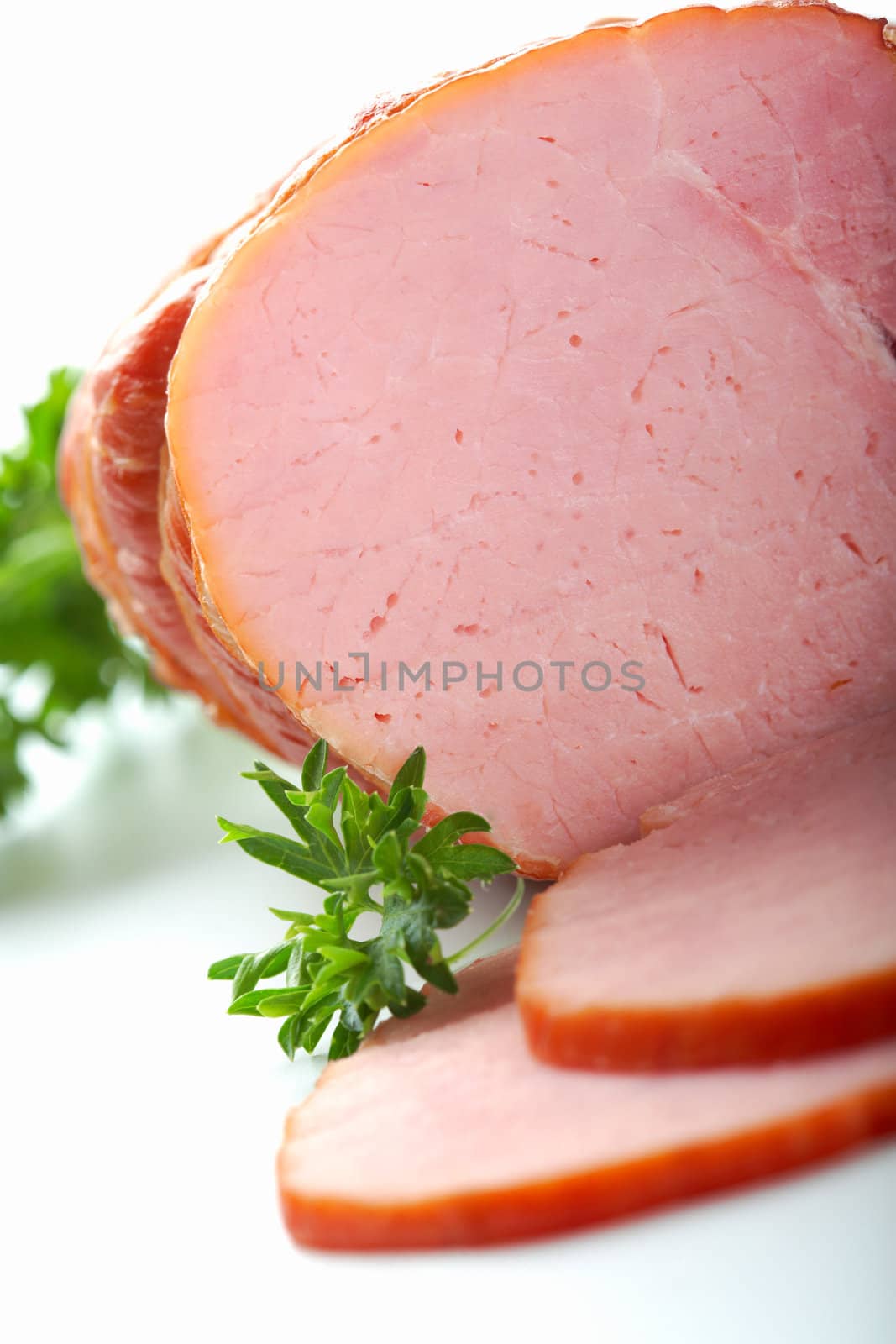 A close-up picture of ham with two cutted slices.