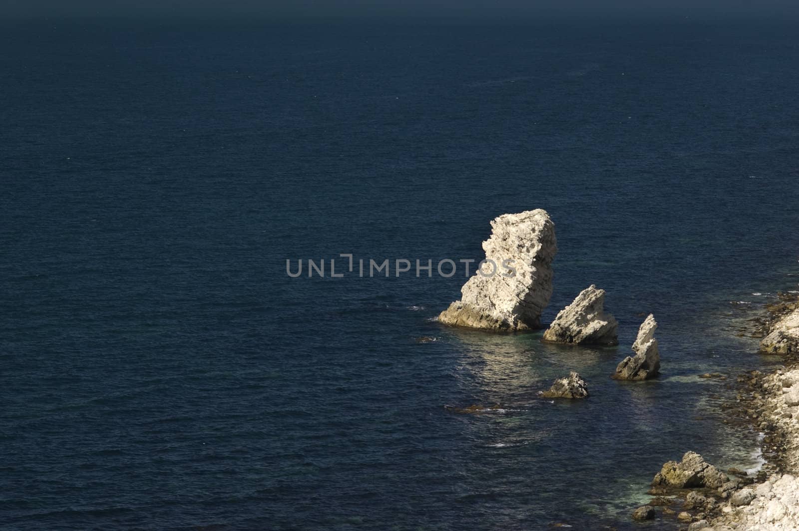 limestone rock in dark gloomy sea water, near the coastline