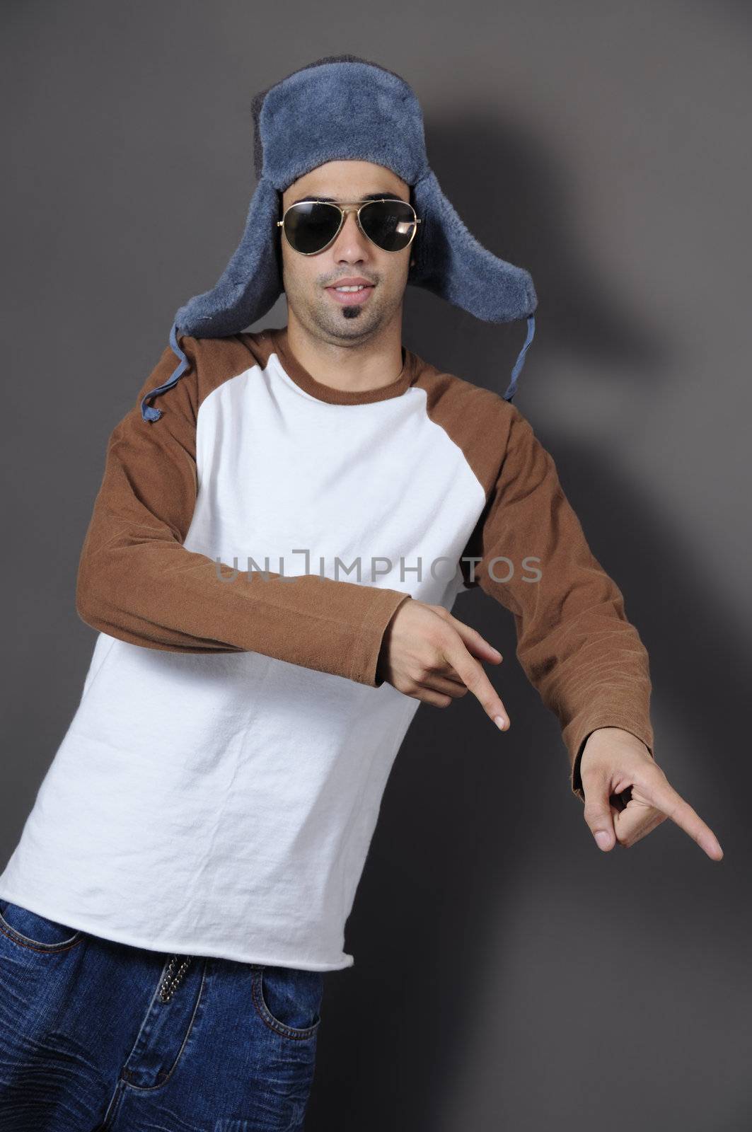 Cool trendy boy in winter hat pinting with fingers