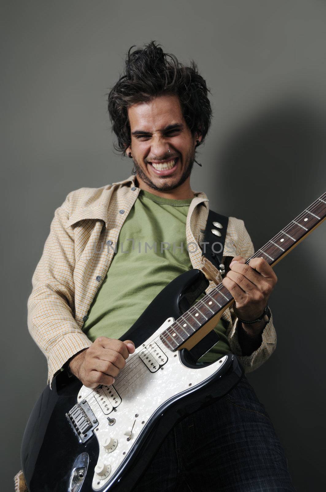 Portrait of young guitarrist with funny expression
