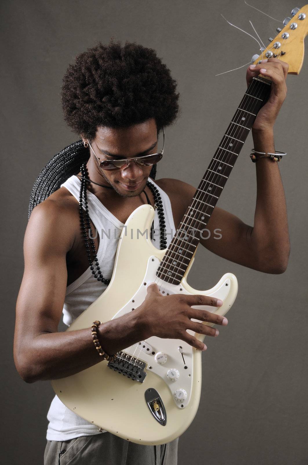 Portrait of young trendy african male playing electric guitar