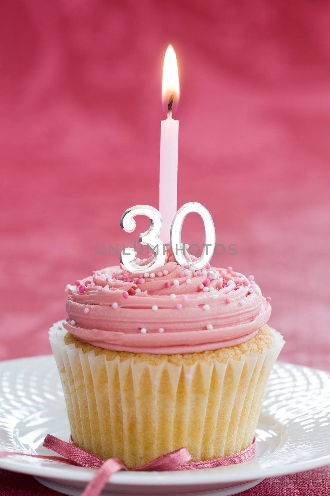 Mini thirtieth birthday cake decorated with a single candle