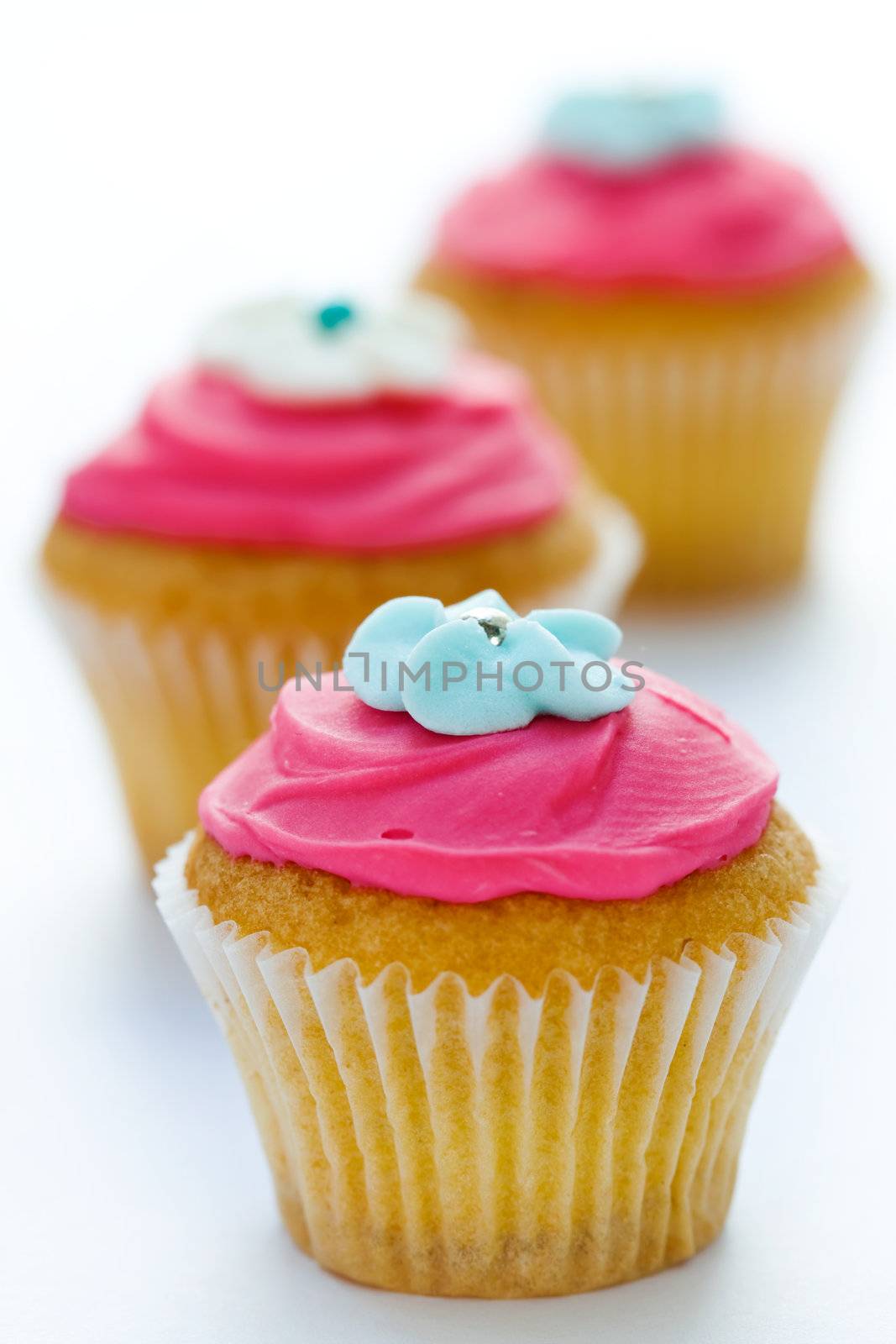 Trio of pink cupcakes against white