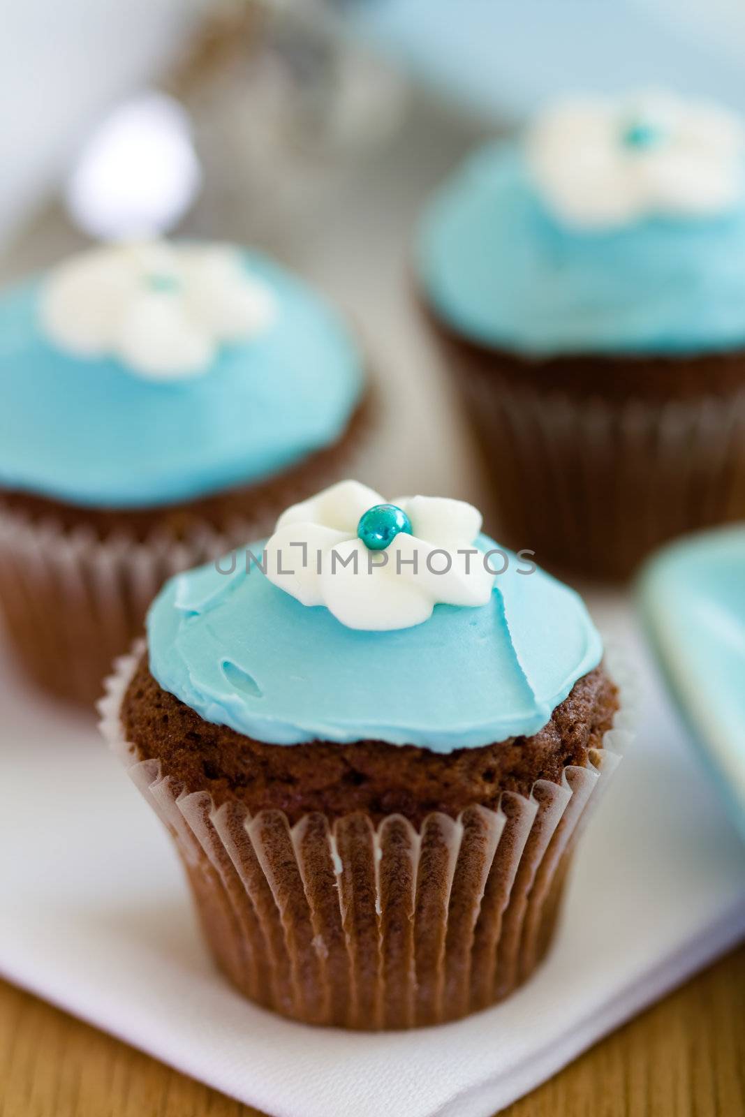 Cupcakes decorated with blue frosting and sugar flowers