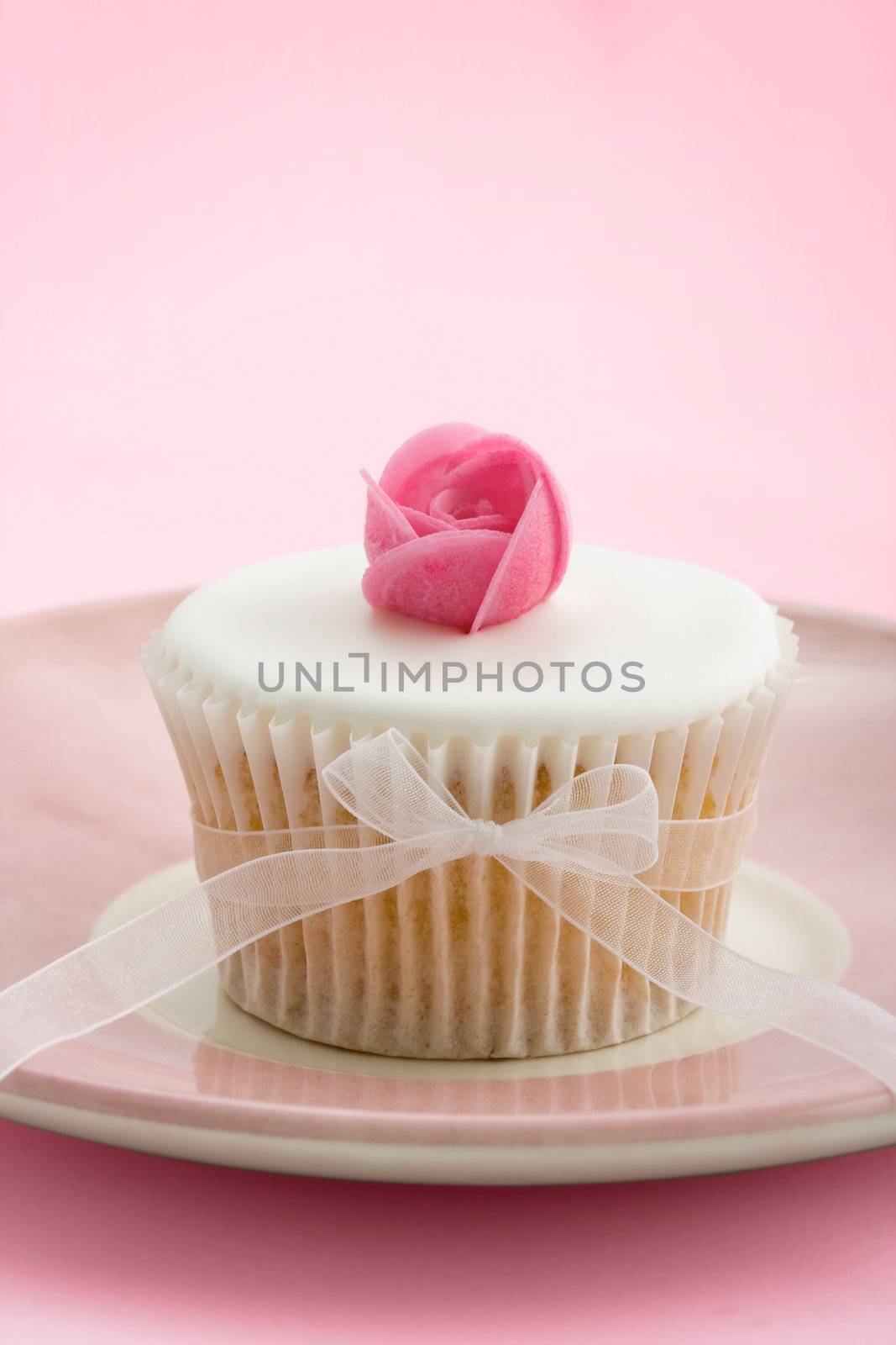 Cupcake decorated with a pink wafer rose