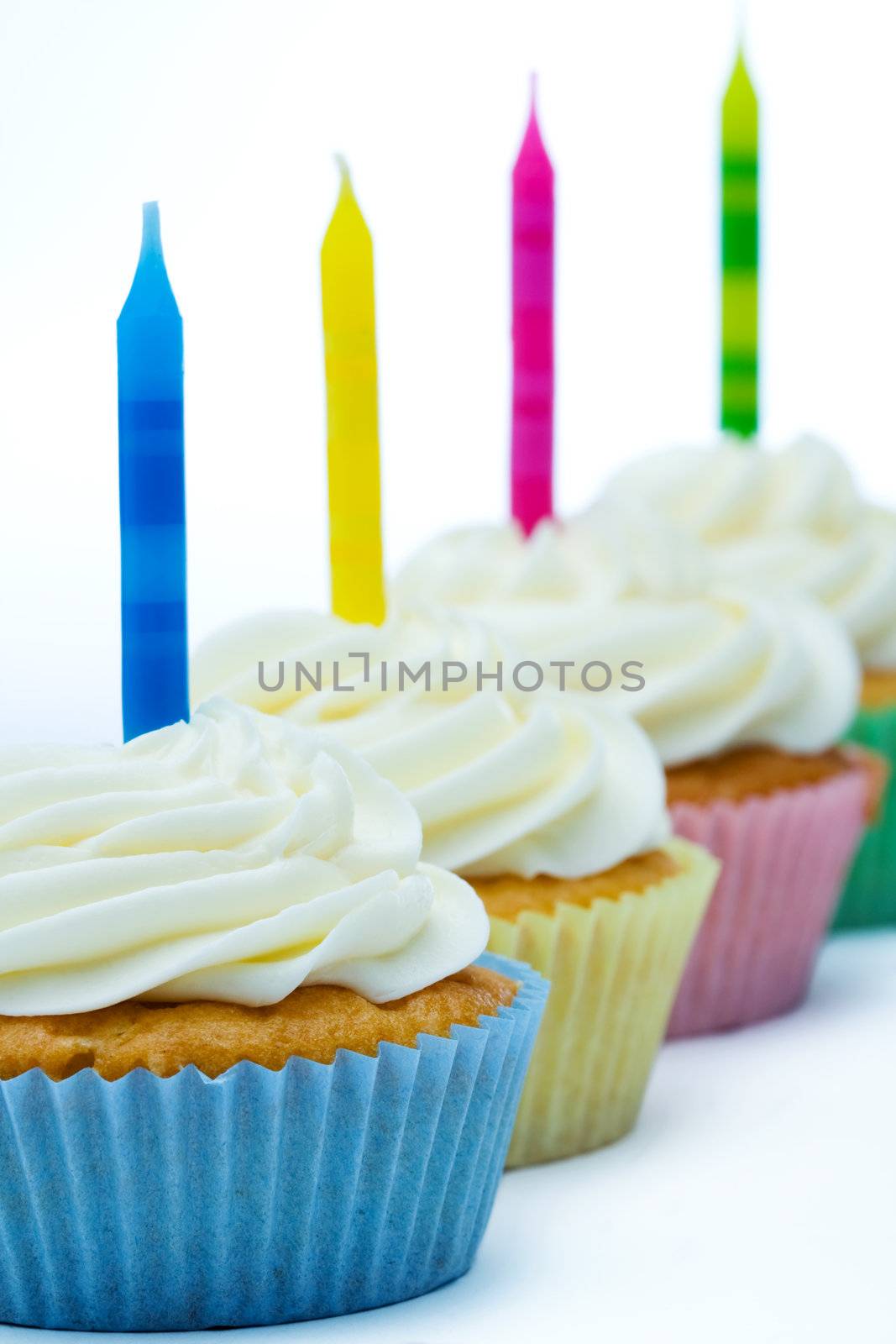 Colorful birthday cupcakes isolated against white