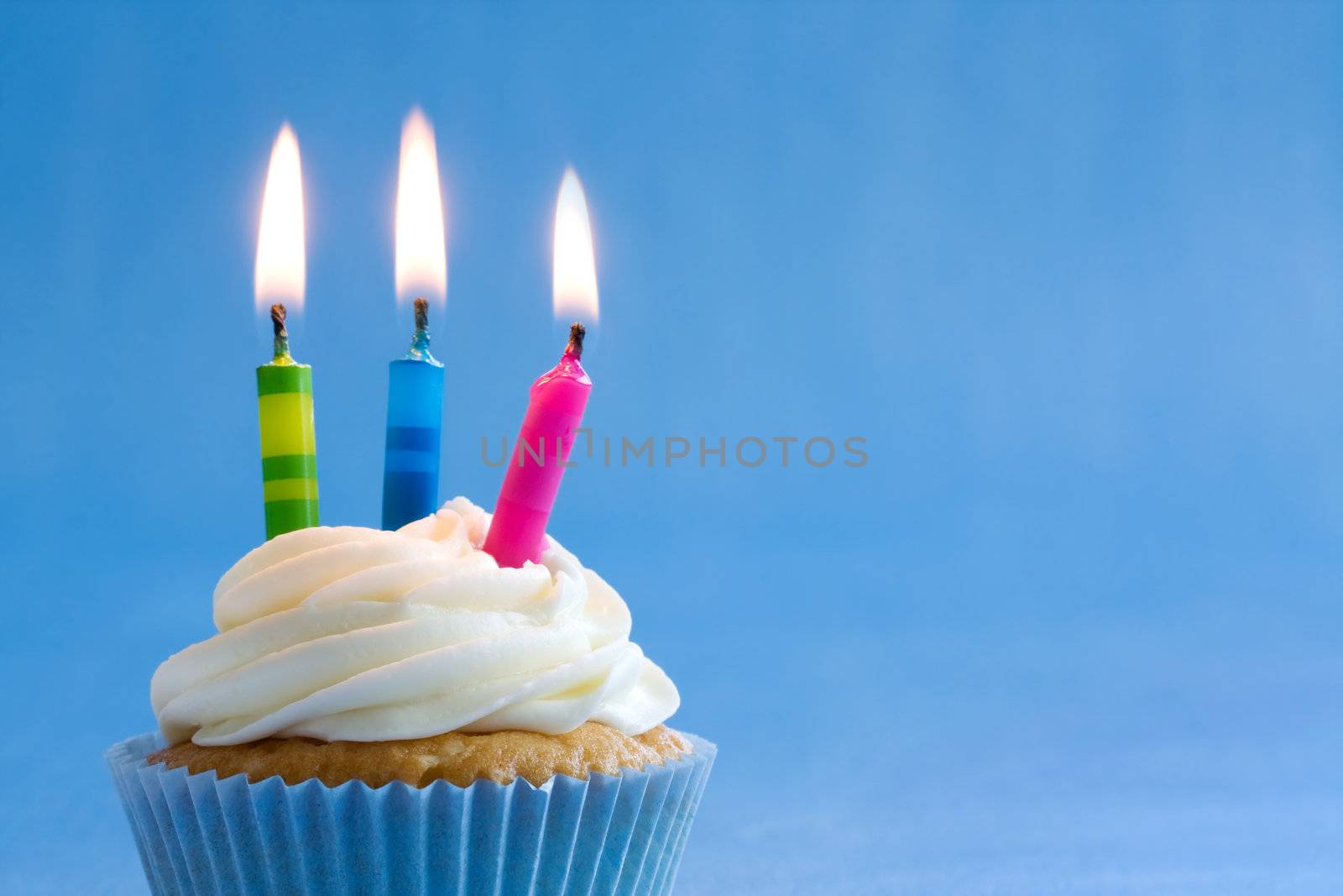 Cupcake decorated with brightly colored candles