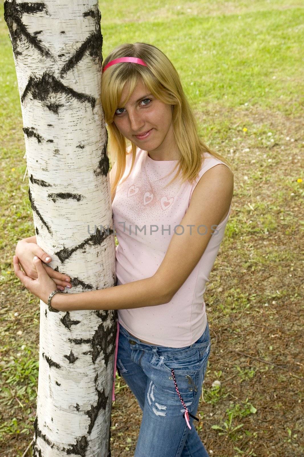 The girl the teenager embraces a birch