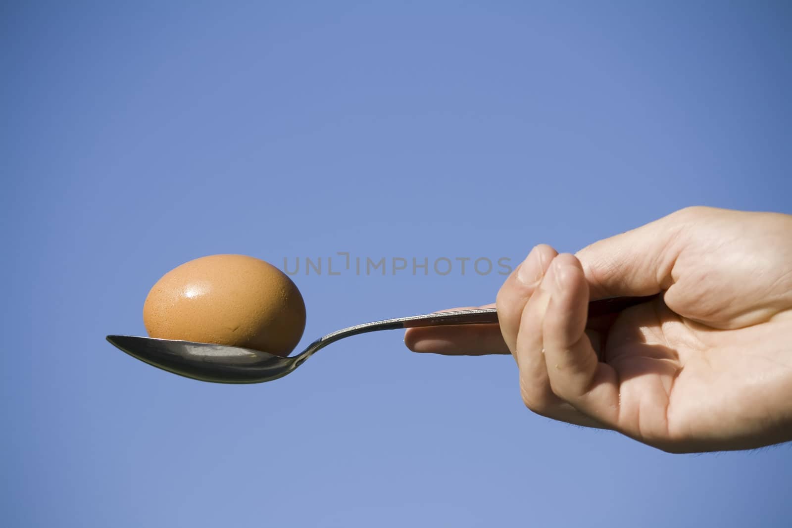 egg and spoon against blue sky by nubephoto