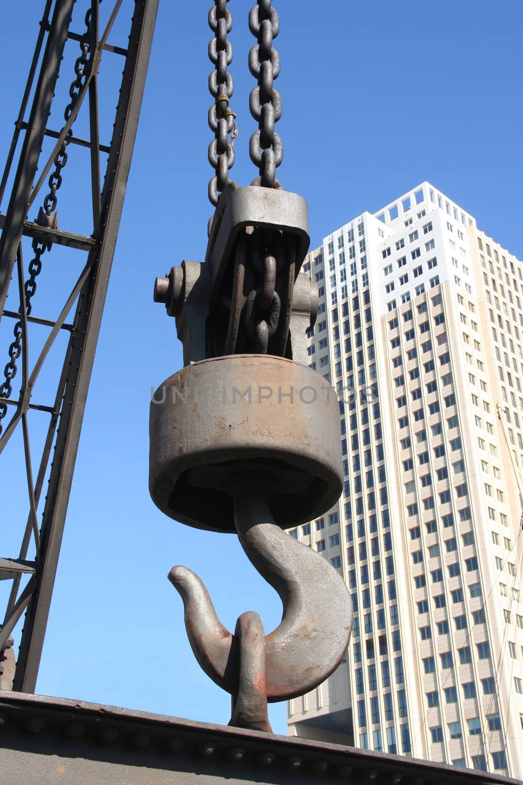 Big lifting hook with backdrop of highrise office building