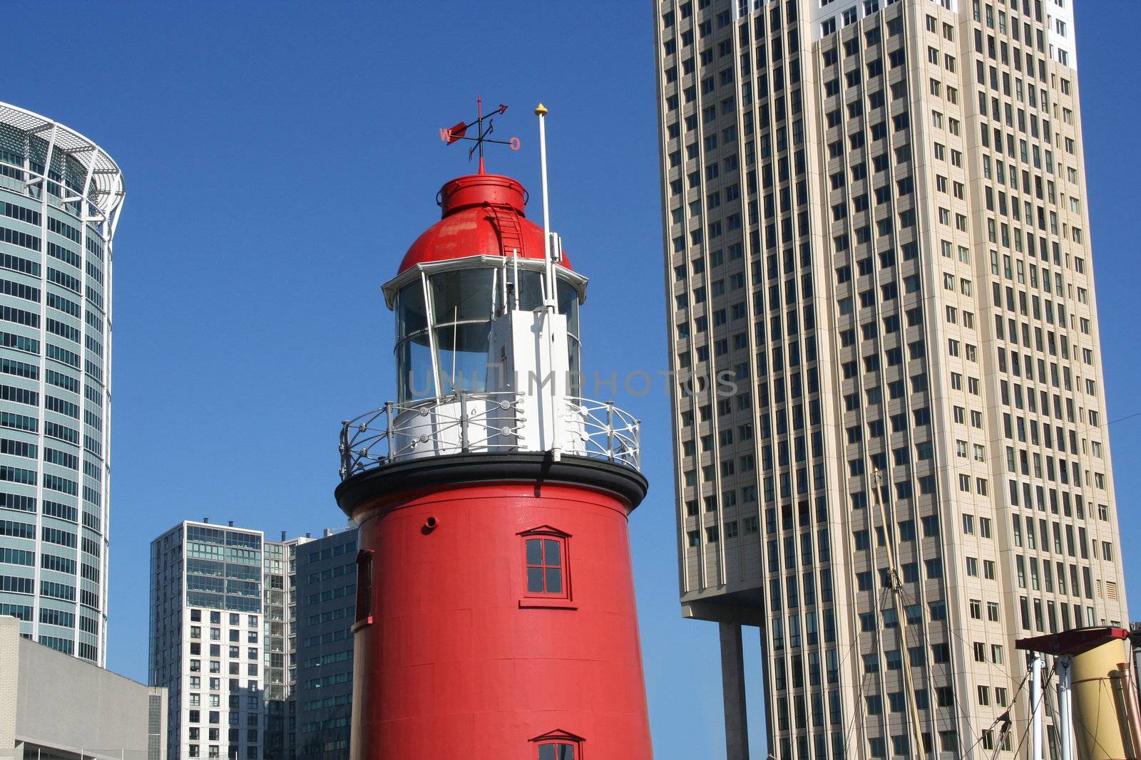 Traditional harbour lighthouse with backdrop of modern highrise in Rotterdam, Holland.